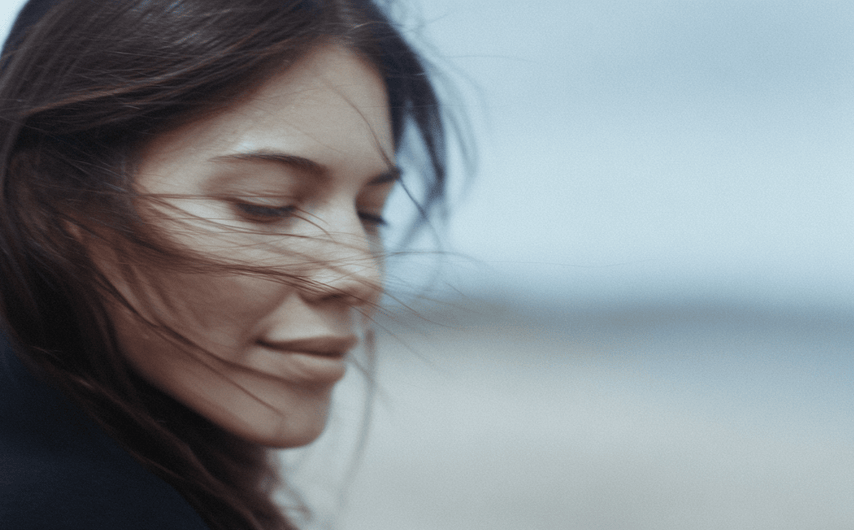 Woman with windblown hair against a blurred background