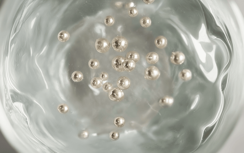 Pearls floating in clear water with a swirling motion