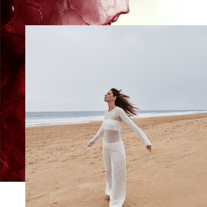 Woman in a white outfit standing on a beach with a red textured corner overlay