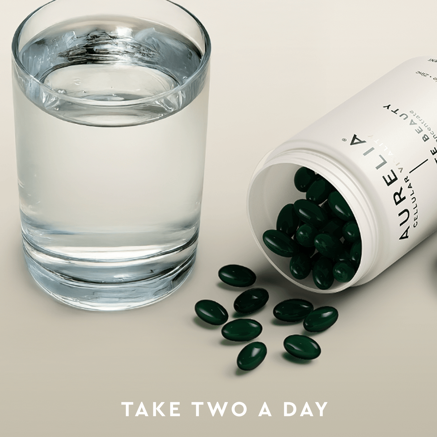 Glass of water next to an open bottle of Aurelia supplements with text 'Take Two A Day'.