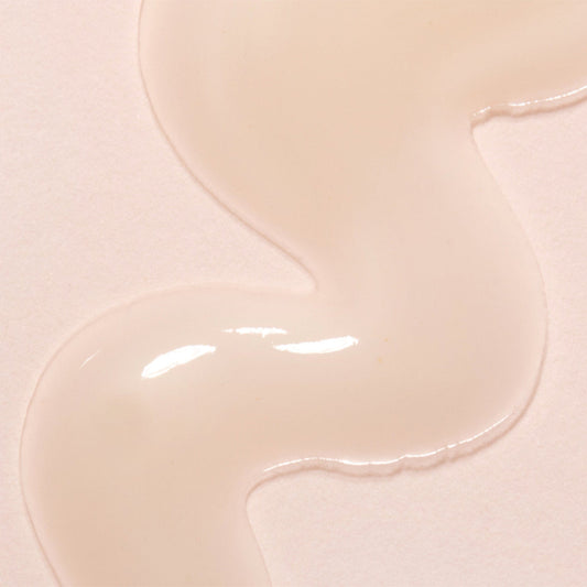 Close-up of beige day oil with a glossy texture on a light pink background