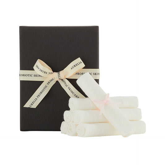 Black gift box with a beige ribbon and white bamboo muslins on a white background
