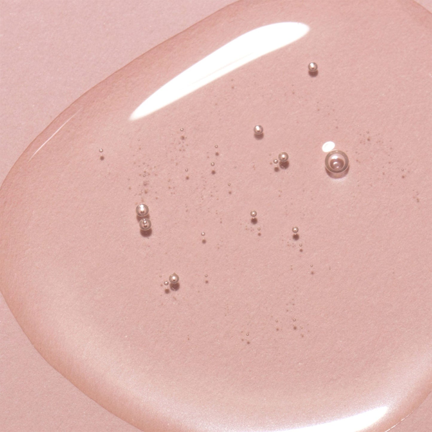 Pink cell repair night oil with small bubbles on a pink background