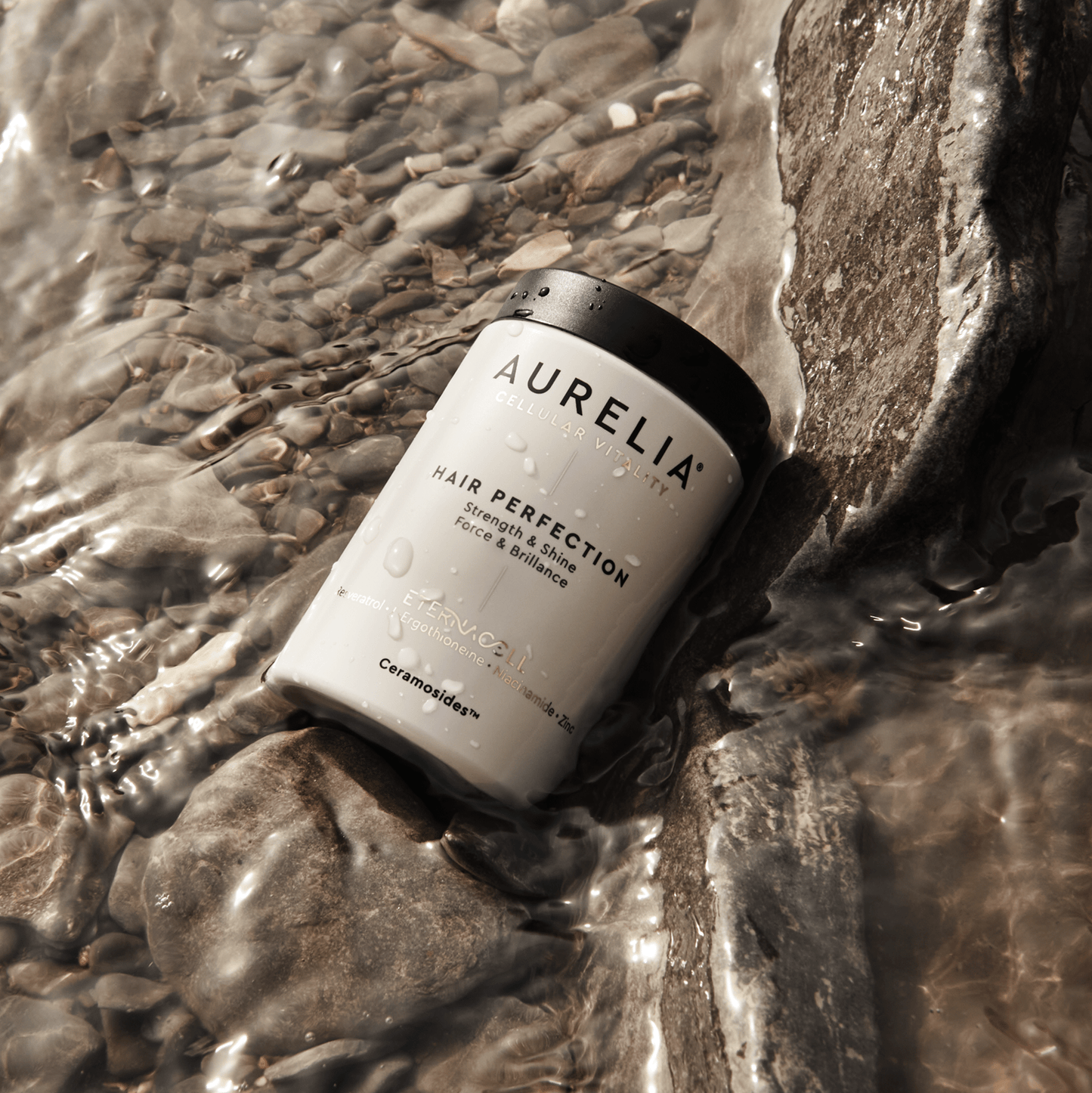 Aurelia hair product bottle on a rocky surface with water