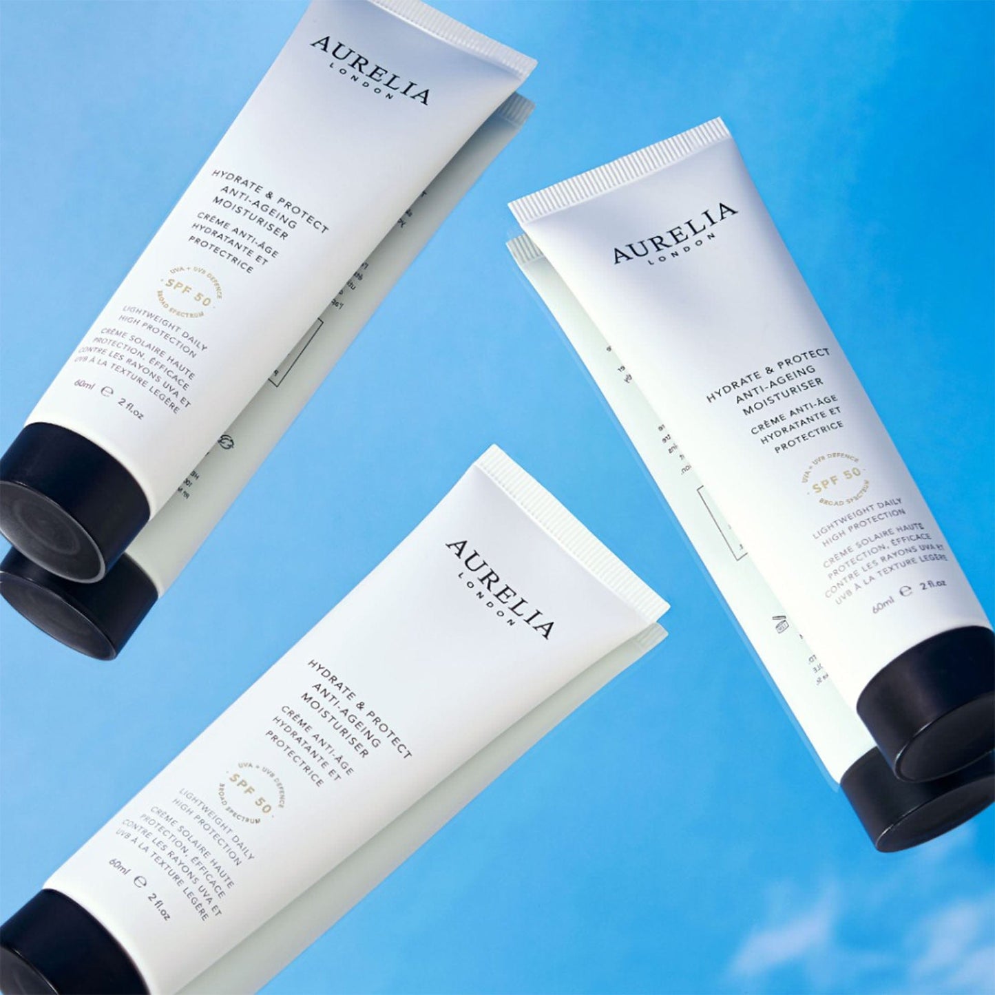 Three Aurelia London hydrate and protect anti-ageing moisturiser on a blue background