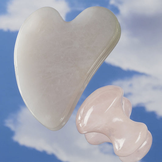Heart-shaped and mushroom shaped guashas against a blue sky with clouds
