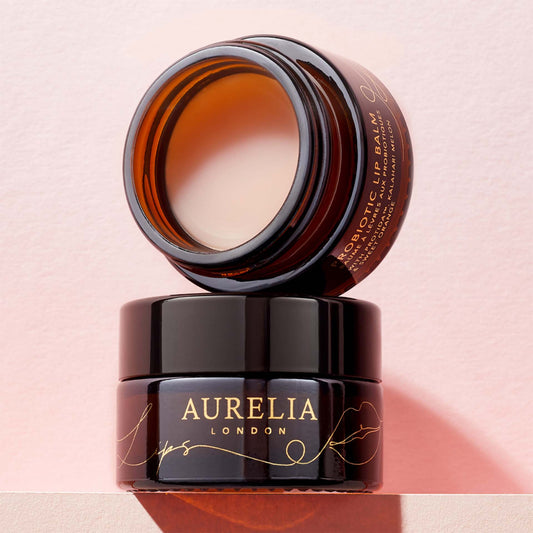 Aurelia London lip balm jar on a pink background