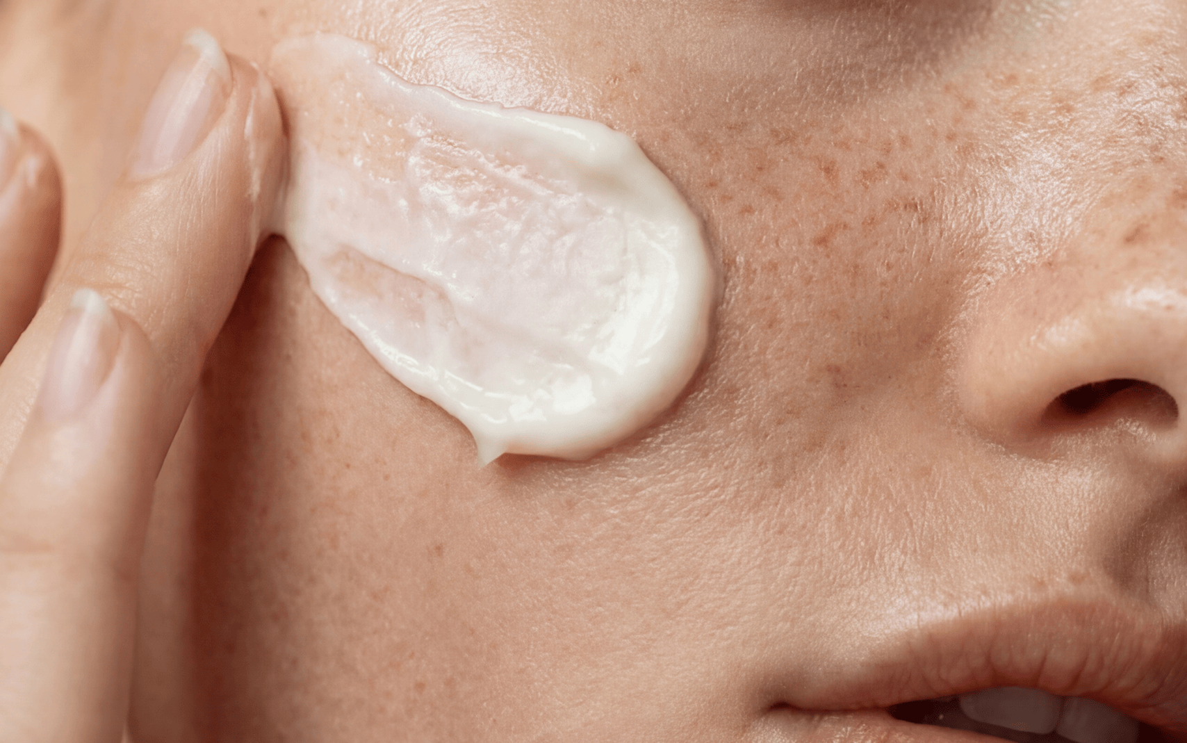 Close-up of a person applying cream to their face