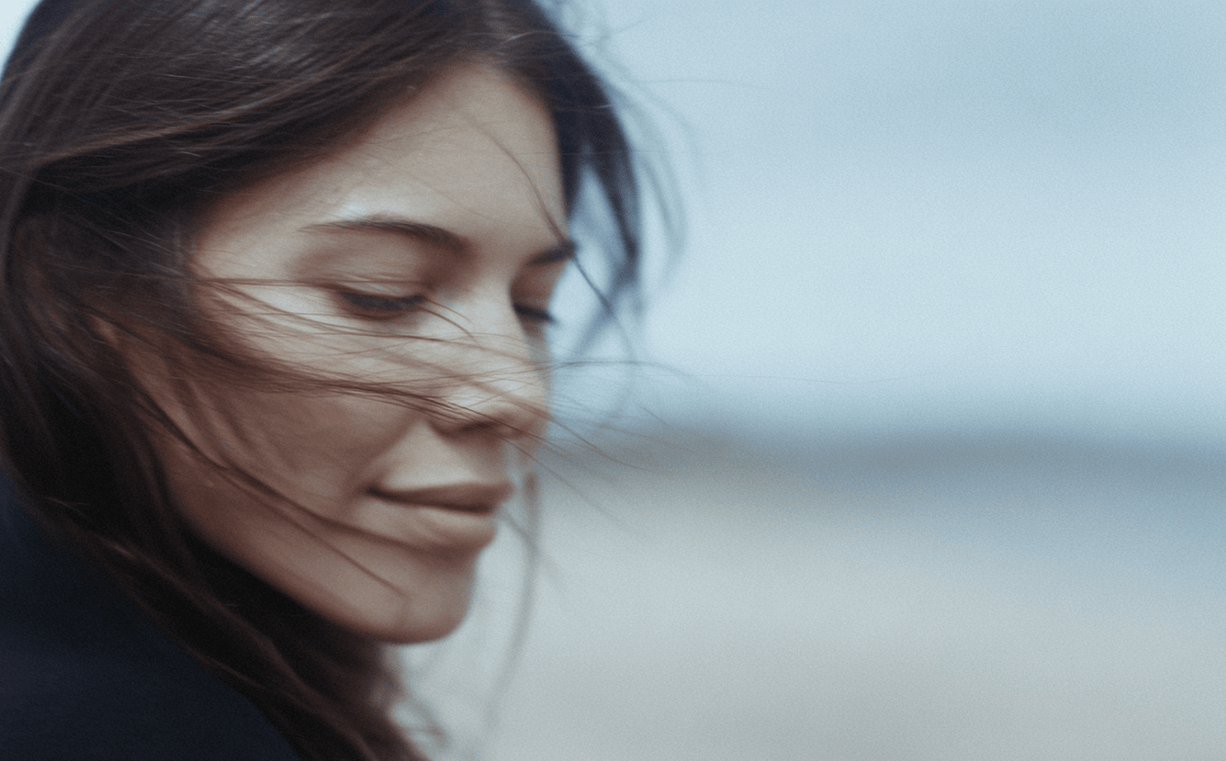 Woman with windblown hair against a blurred background