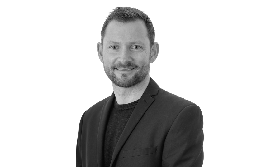 Black and white portrait of a man wearing a suit on a white background