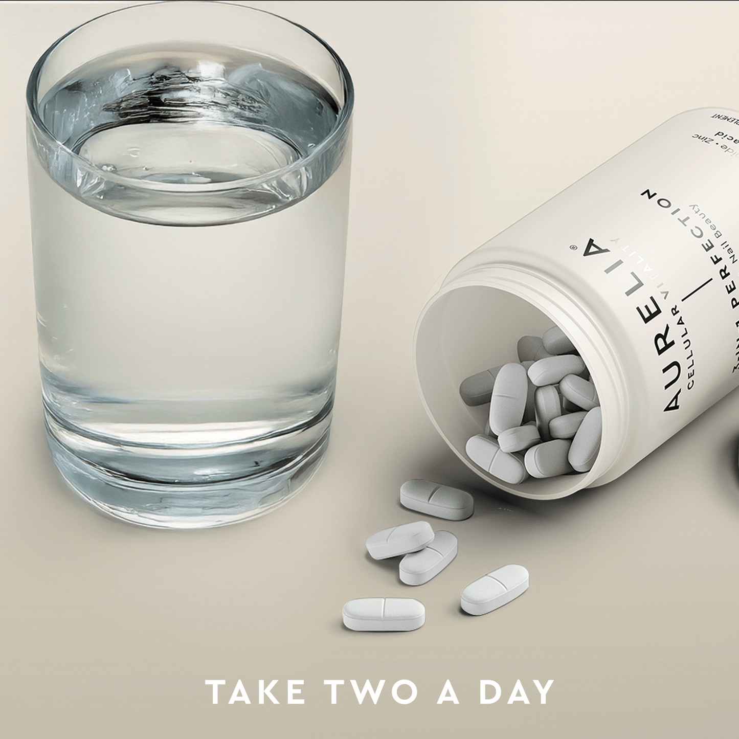 Glass of water next to an open Aurelia supplement bottle with pills on a light background