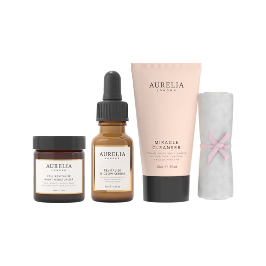 Aurelia London skincare products including serum, cleanser, moisturizer, and towel on a white background
