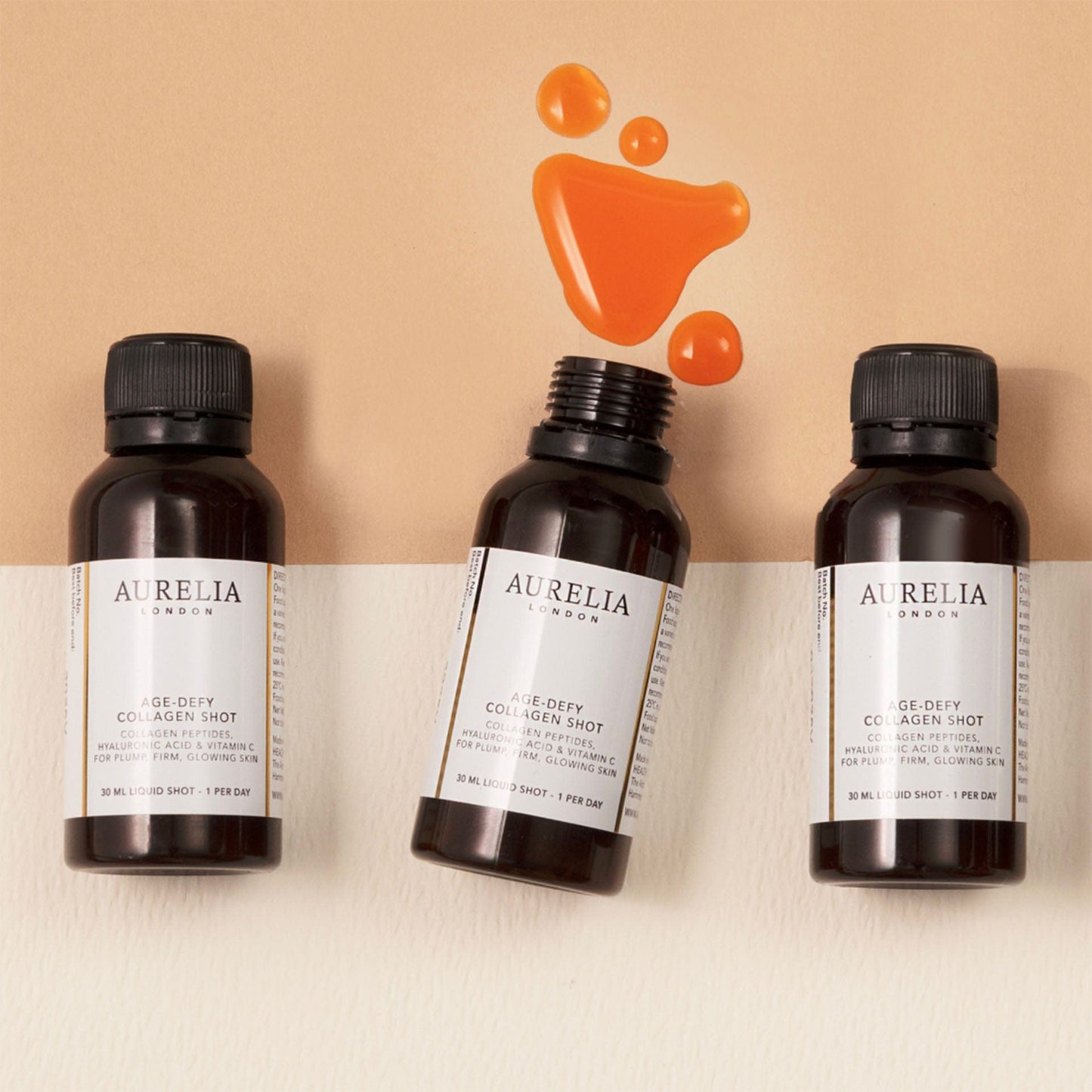 Three Aurelia London age-defying collagen peptide bottles on a beige background with an orange droplet graphic.