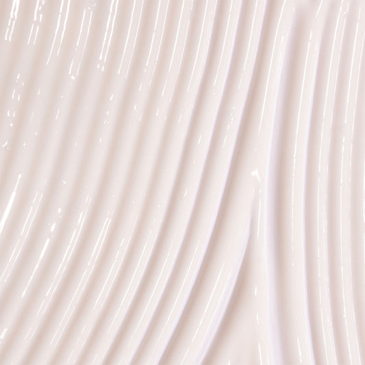 Close-up of beige body serum swatch with a subtle texture