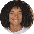 a smiling Woman with curly hair wearing a white shirt 